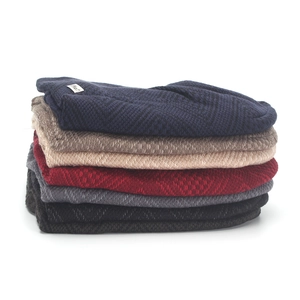Stack of colorful knitted beanies with warm fleece lining and textured diamond weave pattern