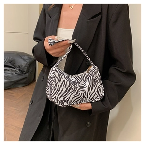 Vue détaillée du sac à main en toile imprimé zèbre au design rétro porté à l'épaule
