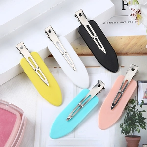 Close-up of five matte colorful no-bend hair clips on a white minimalist display