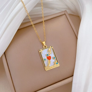 Detail of The Lovers tarot card pendant with gold relief heart on white shell finish