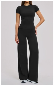 Women's black high-waisted yoga set featuring short sleeve top and wide leg pants