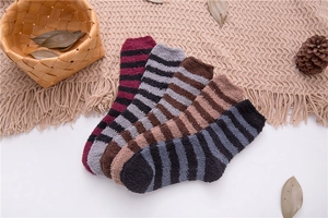 Detail of five striped coral fleece crew socks in assorted colors on a cozy knit blanket