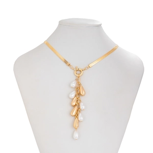 Detail of gold snake chain necklace featuring pearl and metallic teardrop tassels