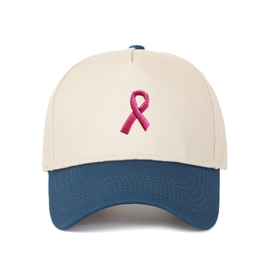 Detail der rosa Schleifenstickerei auf einer beige-marineblauen Baumwoll-Basecap