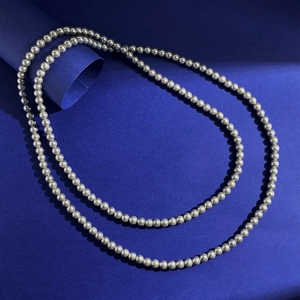 Elegant long pearl necklace with metallic silver beads in a minimalist luxury style