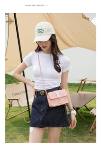 Detail of pink faux leather crossbody bag featuring a delicate pearl pendant charm