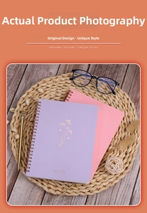 Flat lay of A5 spiral notebooks in purple and pink with gold floral patterns and pen