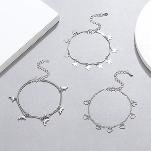 Detailed view of silver S925 bracelets with butterfly, dolphin, and heart charms