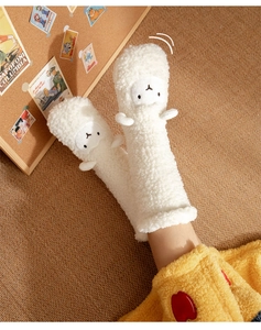 Close-up of white plush knee-high floor socks featuring a 3D cute alpaca animal design