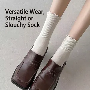 Women's white ruffle knit crew socks styled with brown leather shoes in a versatile stack look