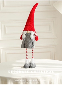 Detailed close-up of a Christmas gnome featuring a red plush hat and white braided hair