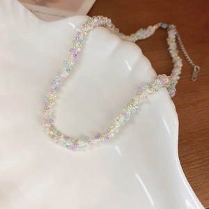 Collier de perles colorées tissées sur plateau coquillage pour un style minimaliste