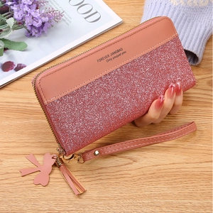 Close-up of pink glitter long wallet with leather tassel and wrist strap for women