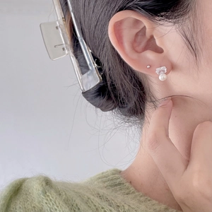 Detailed close-up of a 925 silver stud earring with a square crystal and white pearl