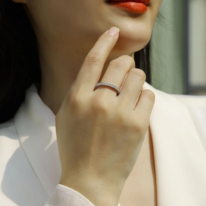 Close-up of a delicate silver eternity ring with pavé stones on a female finger