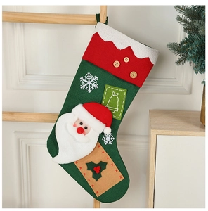 Detail of green Christmas stocking with Santa Claus applique and decorative bell and snowflake