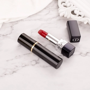 Black cylindrical 10ml aluminum perfume spray bottle with gold trim on marble background