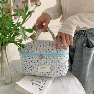 Floral cotton makeup bag with blue yellow dots held by a model in a cozy home setting