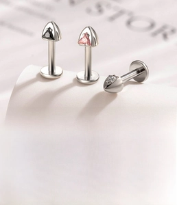 Detail of F136 titanium ear studs with triangular zircon stones and size measurements
