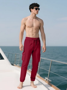 Detail of dark red cargo pants featuring a drawstring waist and large side pockets