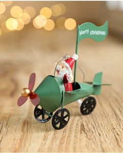 Detail of a vintage green metal airplane ornament with Santa Claus and Merry Christmas flag