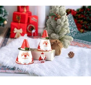 Boîte cadeau de Noël conique avec motif Père Noël posée sur un tapis en fausse fourrure