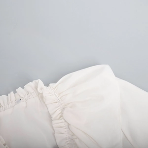 Detailed view of ruffle stitching and premium white chiffon fabric on the V-neck dress