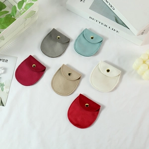 Flat lay of colorful velvet jewelry pouches with gold snap buttons in an aesthetic scene