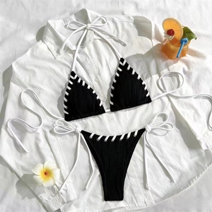 Bikini licou noir texturé avec bordures tressées blanches sur fond de chemise blanche