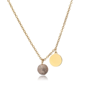 Close-up of gold-plated pendant with polished round disk and natural textured stone bead