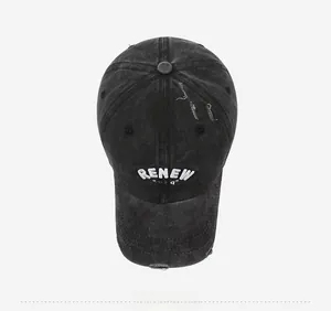 Close-up of distressed black denim baseball cap showing RENEW 3D embroidery and vintage holes