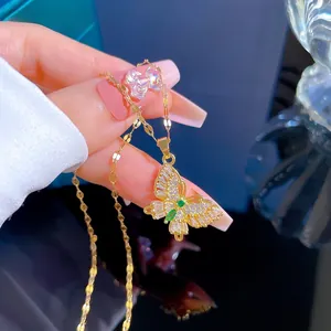 Detail of gold butterfly necklace with green gemstone inlay and micro-pave zircons