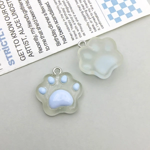 Close-up of cute resin cat paw pendants for DIY jewelry making in blue and white colors