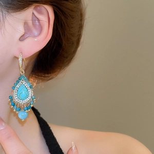 Detailed close-up of bohemian turquoise teardrop earrings with elegant beaded tassels
