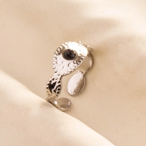Close-up of adjustable silver steel ring featuring a round black gemstone inlay
