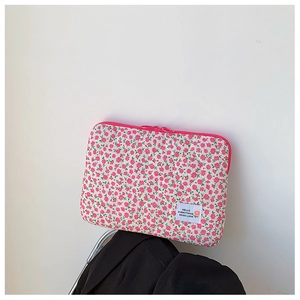 Floral quilted laptop sleeve with pink flowers and a red zipper on a white fabric