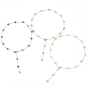 Detail of Y-shaped necklaces with strawberry crystal beads and gold heart pendants