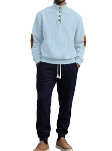 Detail of light blue cable knit sweater featuring button stand collar and brown elbow patches