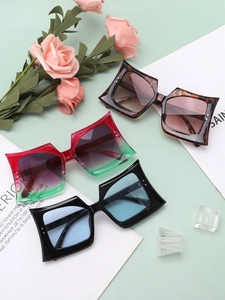 Detailed view of oversized square sunglasses in tortoiseshell, red-green, and black colors