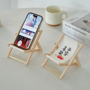 Miniature wooden beach chair phone stand with canvas seat featuring artistic illustration