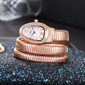 Macro shot of rose gold snake-shaped watch dial with diamond-set bezel and spiral band