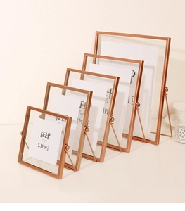 Set of five rose gold metal photo frames with glass panels in graduated sizes