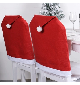 Detail of red and white Santa hat chair covers with pompoms on wooden chairs