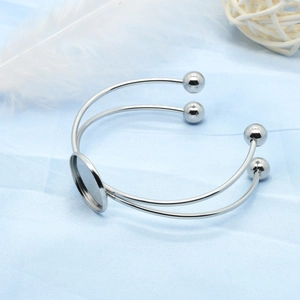 Detail view of double-layer stainless steel bangle with round bezel base and silver beads
