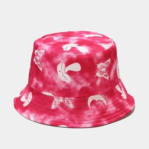 Dettaglio di un cappello da pescatore tie-dye con farfalle e funghi disegnati a mano