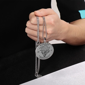 Close-up of engraved silver round pendant with twist chain showing intricate details