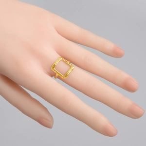 Minimalist square geometric gold ring with irregular texture shown on a hand model