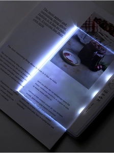 Detailed view of LED flat plate reading light illuminating a book page in the dark