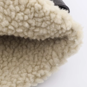 Close-up of the thick warm off-white fleece lining and black leather trim of the jacket
