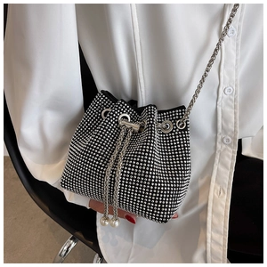 Close-up of sparkling rhinestone bucket bag with drawstring closure and pearl accents